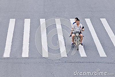 Man on motorcycle crossing zebra path, Yantai, China Editorial Stock Photo